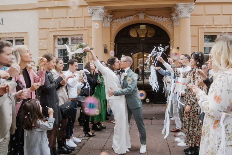 Hochzeitspaar küssend vor der gesamten Belegschaft; Preise Hochzeitsfotograf Alpirsbach